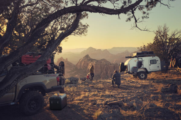 Camper trailer and people near a canyon.